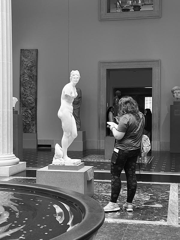 在大都会博物馆，学生站着为雕塑画草图
