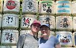 Two students posing for photo in front of colorful wall with Japanese lettering