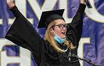 Student raises arms in air as she cheers after receiving degree during December 2021 graduation ceremony. 